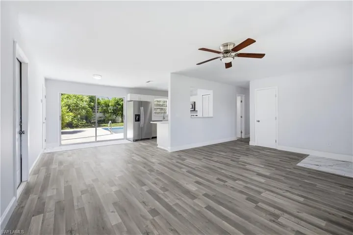 Open-concept living area featuring wood-finish flooring and a ceiling fan with integrated lighting