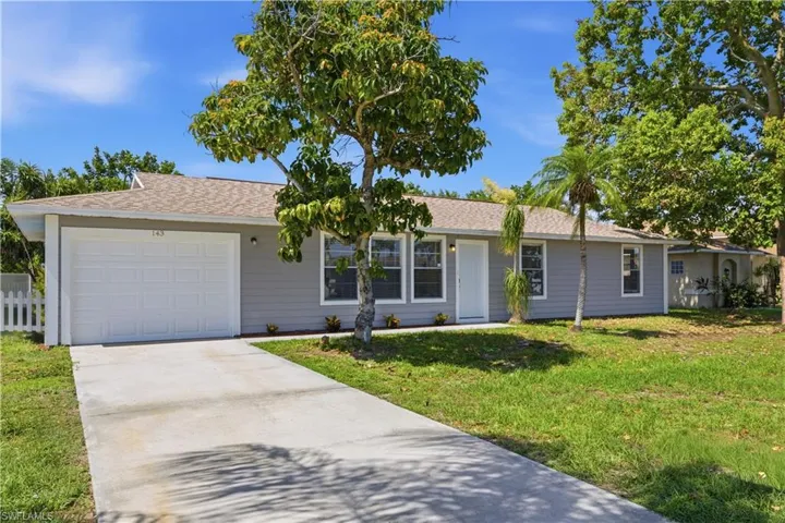 Single-story residence featuring gray siding, a white garage door, and a matching white entry door
