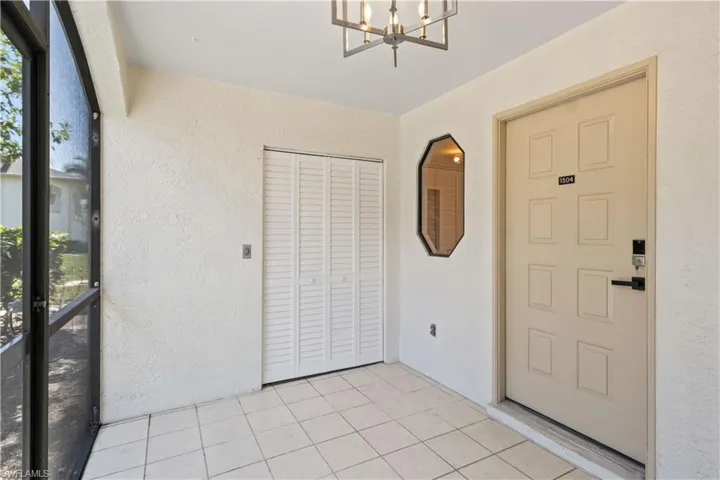 A private, screened entryway with a convenient storage area that includes a brand-new washer and dryer.
