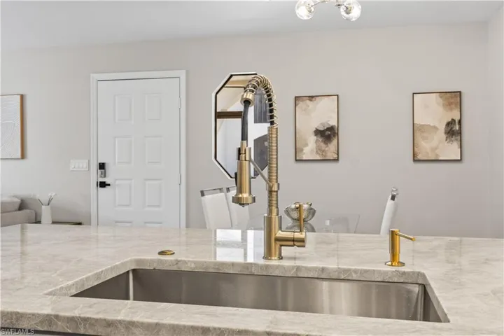 This stunning kitchen sink is complemented by elegant gold fixtures that add a touch of luxury to the space.
