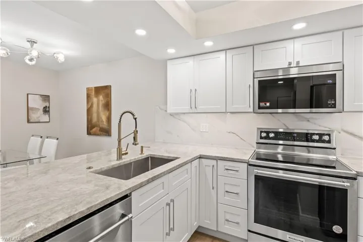 A sleek, fully renovated kitchen with brand-new stainless-steel appliances, custom cabinetry, and stunning countertops.