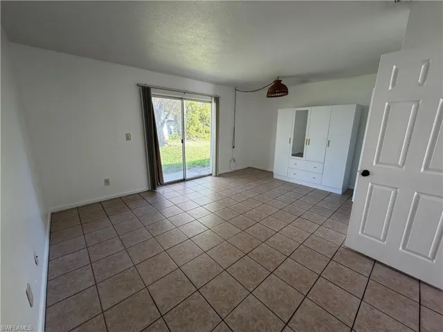 Unfurnished bedroom with access to backyard