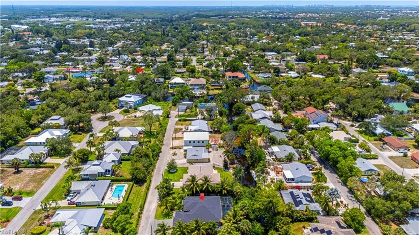 Aerial view of property and surrounding area with nearby suburban area