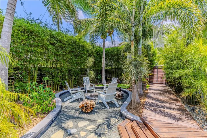 View of patio with an outdoor fire pit and a wooden deck