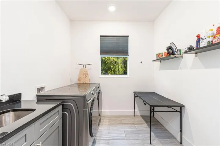 Laundry area with washer and dryer, cabinet space, and baseboards