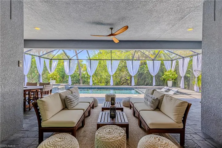 View of patio with outdoor lounge area, a lanai, ceiling fan, and a pool with connected hot tub