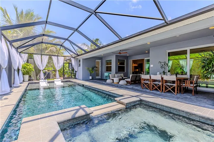 View of swimming pool featuring ceiling fan, a patio area, an outdoor hangout area, a lanai, and a pool with connected hot tub