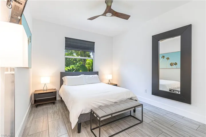 Bedroom featuring baseboards, ceiling fan, and wood finish floors