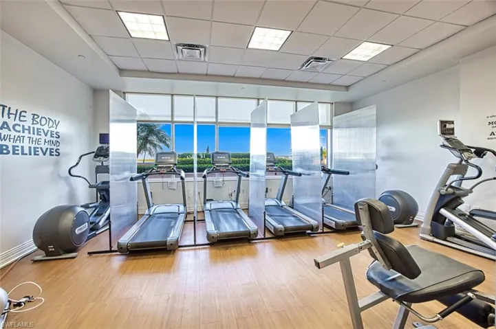 Workout area featuring a paneled ceiling and light hardwood / wood-style flooring