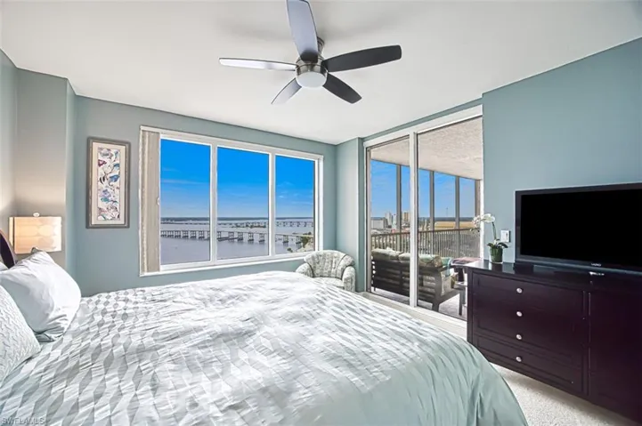 Carpeted bedroom featuring ceiling fan and access to exterior