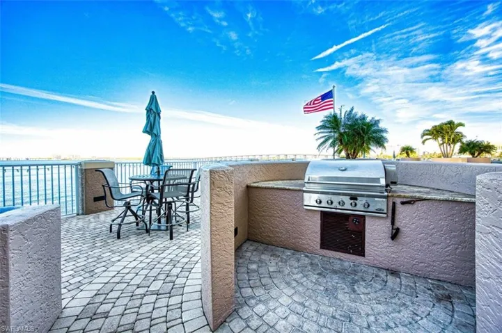 View of patio featuring exterior kitchen and a grill