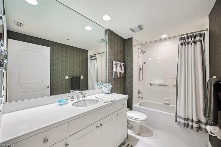 Full bathroom featuring toilet, shower / tub combo, tile patterned flooring, and vanity