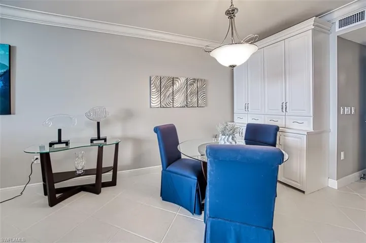Dining space featuring ornamental molding and light tile patterned flooring