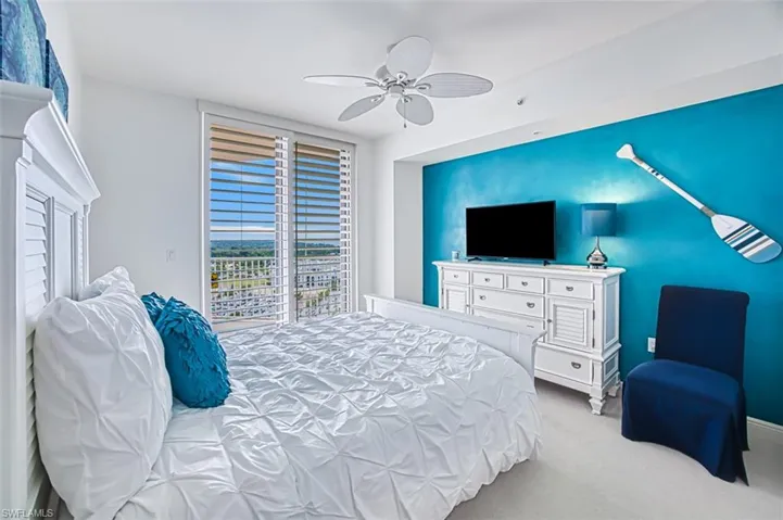 Carpeted bedroom featuring ceiling fan and access to outside