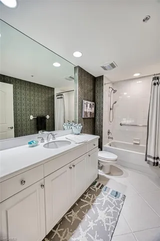 Full bathroom featuring toilet, tile patterned flooring, shower / bath combo, and vanity