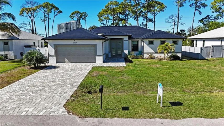 Ranch-style home featuring decorative driveway, stucco siding, and a garage