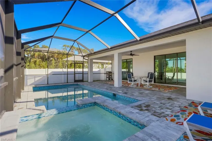 View of pool with a sunroom, a lanai, a patio area, and a pool with connected hot tub
