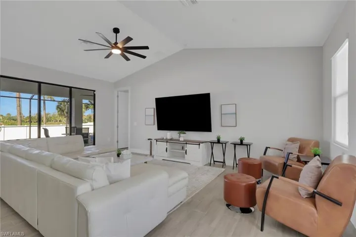 Living room featuring wood tiled floors, vaulted ceiling, and a ceiling fan
