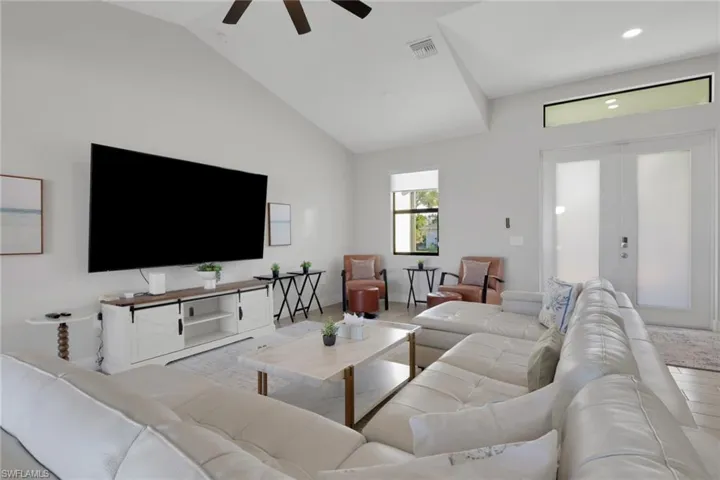 Living area with lofted ceiling, french doors, and a ceiling fan