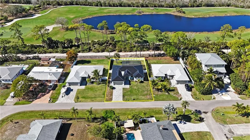 Aerial view of residential area with a large body of water and a golf course
