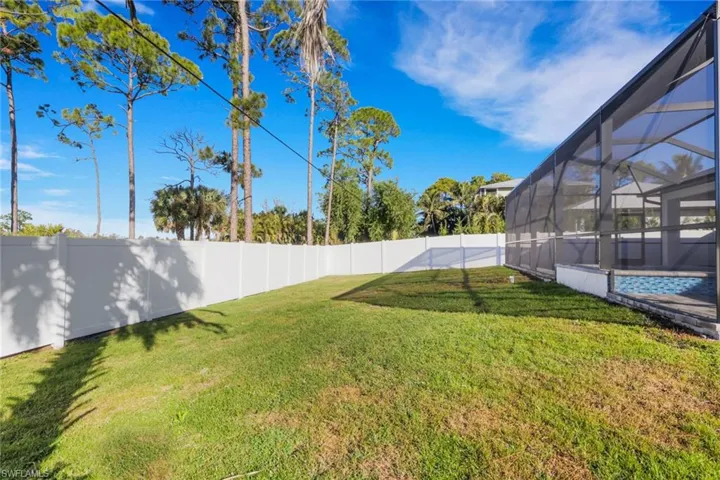 Fenced backyard with a sunroom, glass enclosure, and an outdoor pool