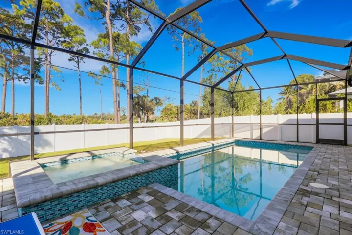 View of pool with a lanai, a sunroom, a pool with connected hot tub, a fenced backyard, and a patio area