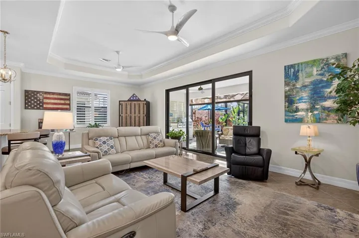 Living area featuring crown molding, a tray ceiling, and ceiling fan