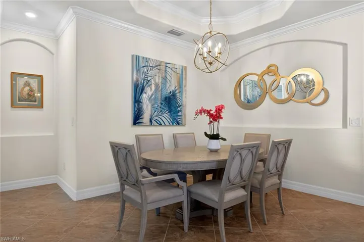 Dining area with crown molding and a chandelier