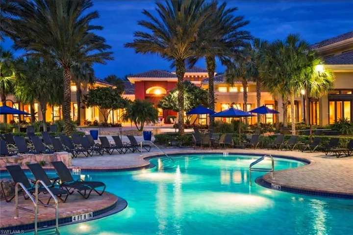 Pool at twilight featuring a community pool and a patio