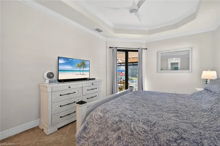 Bedroom with access to outside, a raised ceiling, crown molding, a ceiling fan, and light tile patterned floors