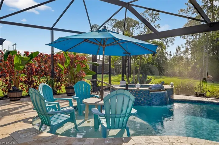 Combined pool / hot tub with a lanai, a patio area, a sunroom, and a lawn