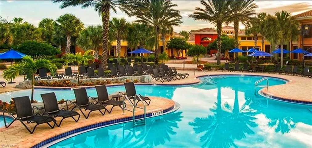 Pool at dusk featuring a community pool and a patio area