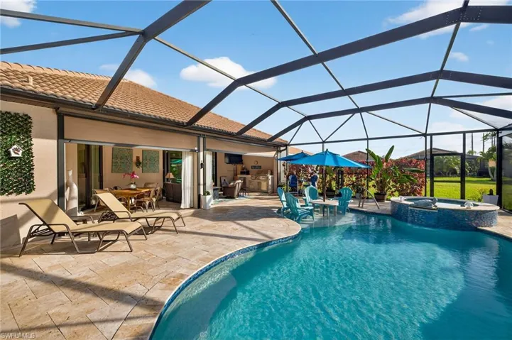Integrated pool / hot tub with outdoor dining space, a sunroom, a lanai, and a patio area
