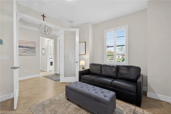 Living area featuring light tile patterned floors and a chandelier
