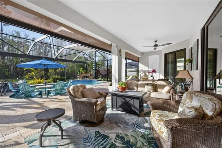 View of patio with glass enclosure, outdoor seating, ceiling fan, a sunroom, and an outdoor pool