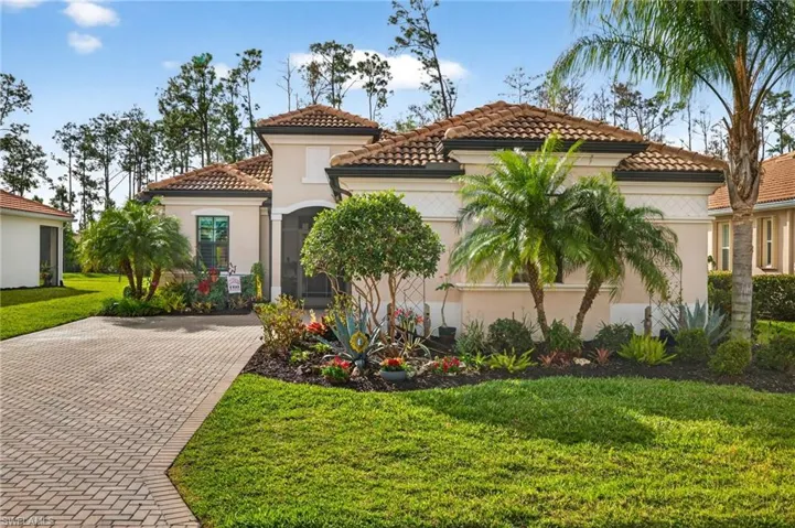 Mediterranean / spanish home with a front lawn, stucco siding, and a tiled roof