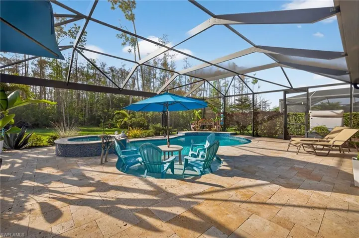 Relaxing pool / spa featuring a sunroom, glass enclosure, and a patio