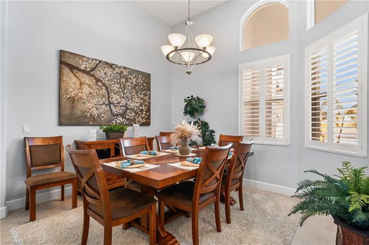 Dining area with a notable chandelier, a towering ceiling, and light tile patterned floors