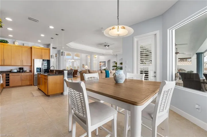 Dining room featuring sink, light tile patterned flooring, a healthy amount of sunlight, and ceiling fan