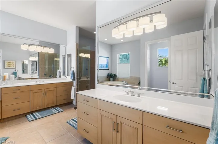 Bathroom featuring separate vanities, separate shower and tub.