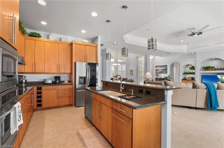 Kitchen island with sink, stainless steel appliances, 42" wood honey cabinets.