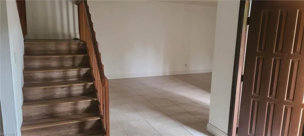 Staircase featuring tile patterned flooring and baseboards
