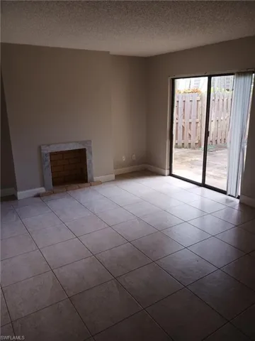 Unfurnished living room with a textured ceiling and tile patterned floors