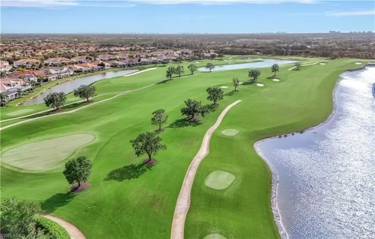 Aerial perspective of suburban area featuring a large body of water and a local golf course