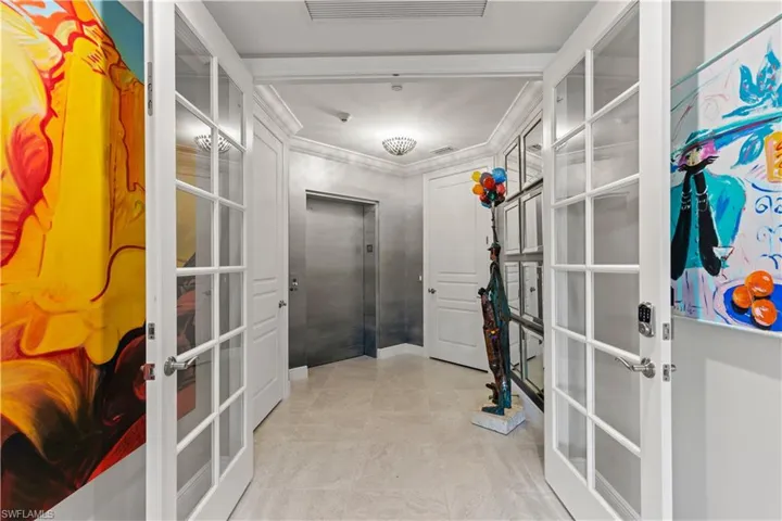 Corridor featuring elevator, french doors, and crown molding