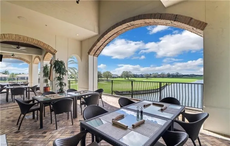 View of patio featuring outdoor dining space, golf course view, ceiling fan, and a water view