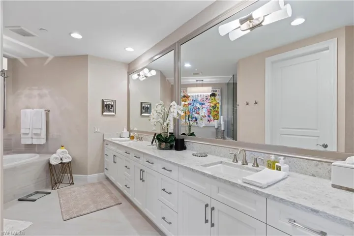 Bathroom with double vanity, a bath, recessed lighting, and a shower stall