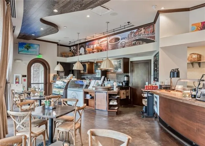 Dining area featuring crown molding, a high ceiling, recessed lighting, and arched walkways