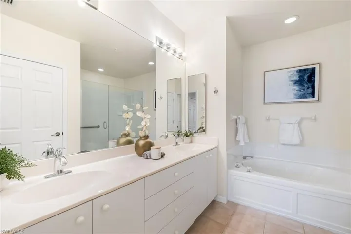 Primary Bathroom with tile patterned floors, separate walk-in shower and tub, toilet closet, and vanity