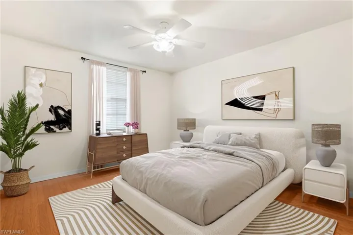 Guest Bedroom featuring wood flooring and ceiling fan. This photo is virtually staged